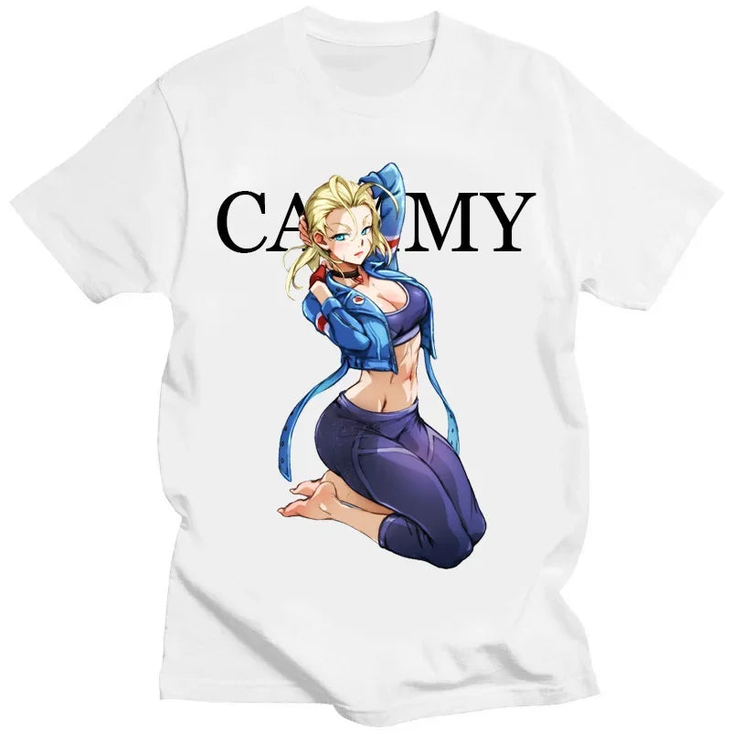 A white short-sleeve t-shirt featuring a graphic print of the anime character Cammy from Street Fighter. The graphic shows Cammy kneeling with her arms crossed over her chest, positioned below the black text 'CAMMY'.